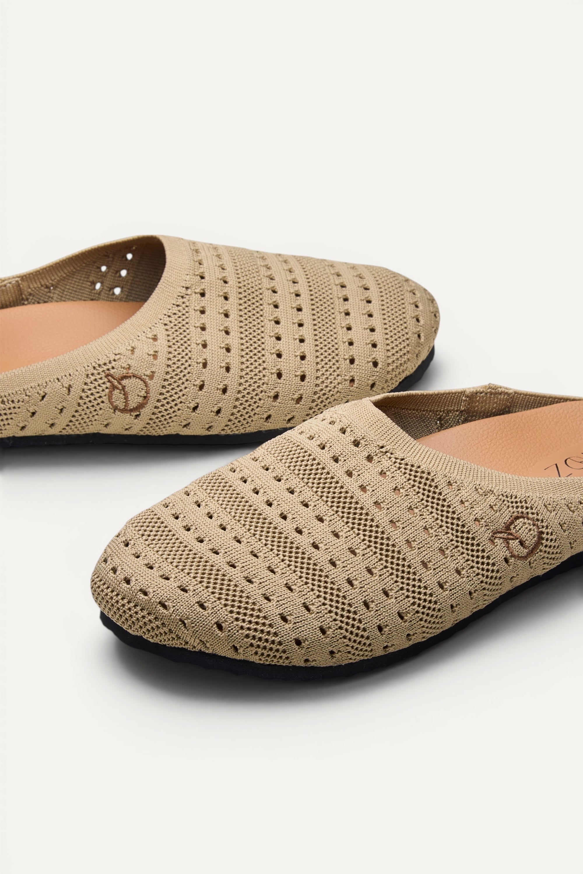 Side view of Rioz Sand Lumi Mules, breathable pointelle knit closed-toe slip-on clogs.