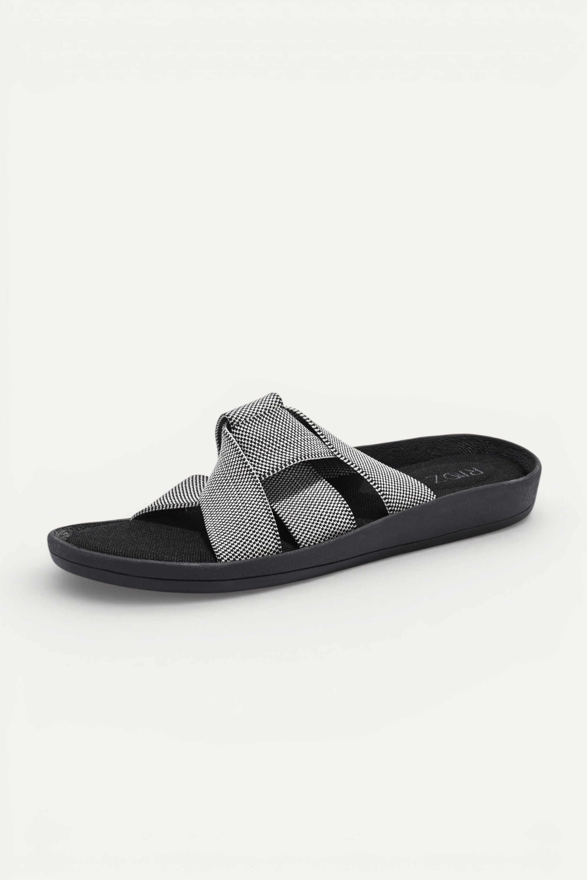 RIOZ eco-friendly slip-on sandals with grey woven bow straps, cushioned tan footbed, and brown sole, designed for lightweight everyday comfort and sustainable style.
