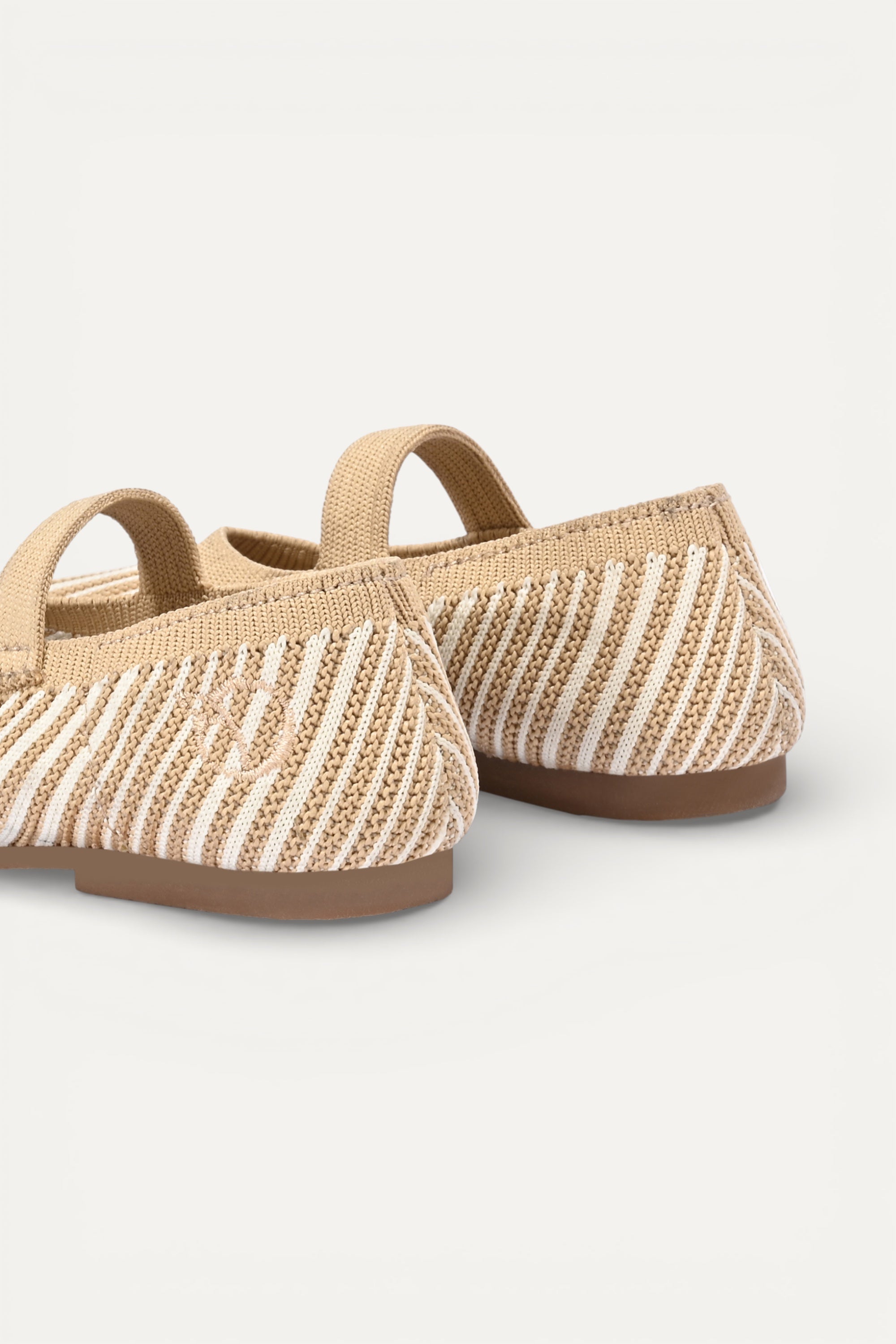 Beige and cream knit Mary Jane flats with strap, breathable striped pattern upper, lightweight flexible sole, comfortable everyday footwear for kids.