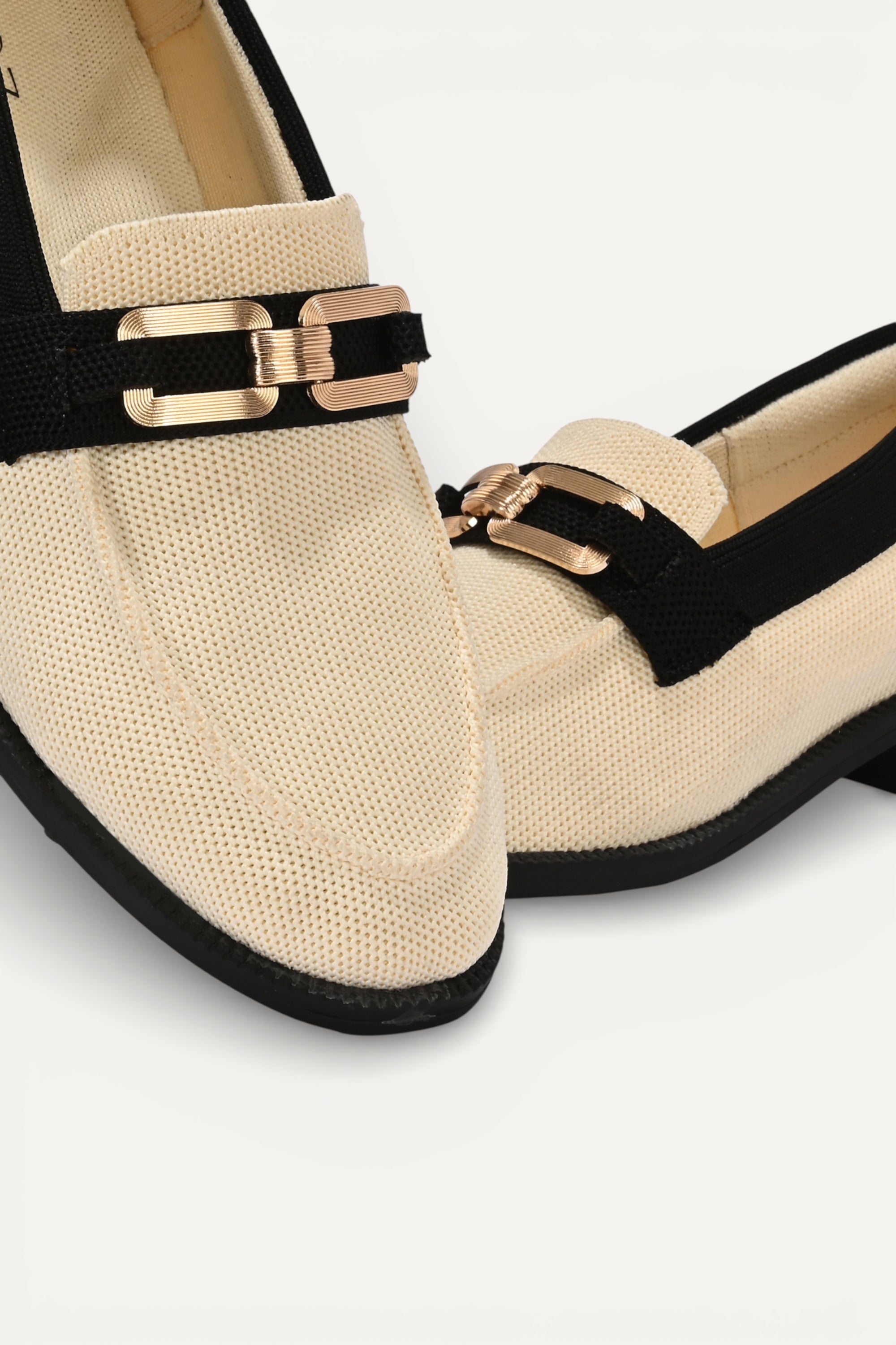 Rioz cream knit slip-on loafers with black trim and gold buckle detail, eco-friendly fabric and cushioned sole casual shoes
