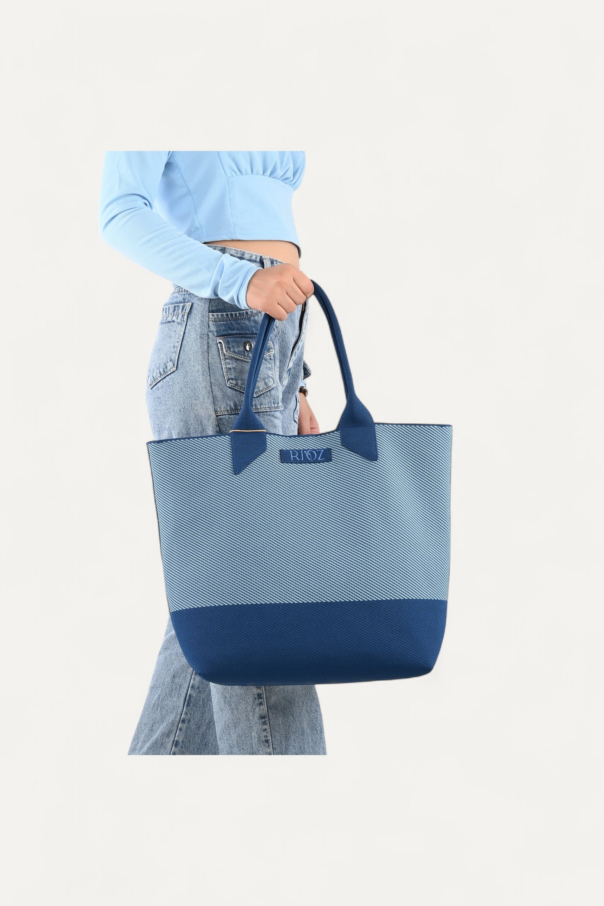 Rioz blue tote bag for women with dual handles, spacious design, and stylish fabric finish made from recycled PET bottles for sustainable everyday use.