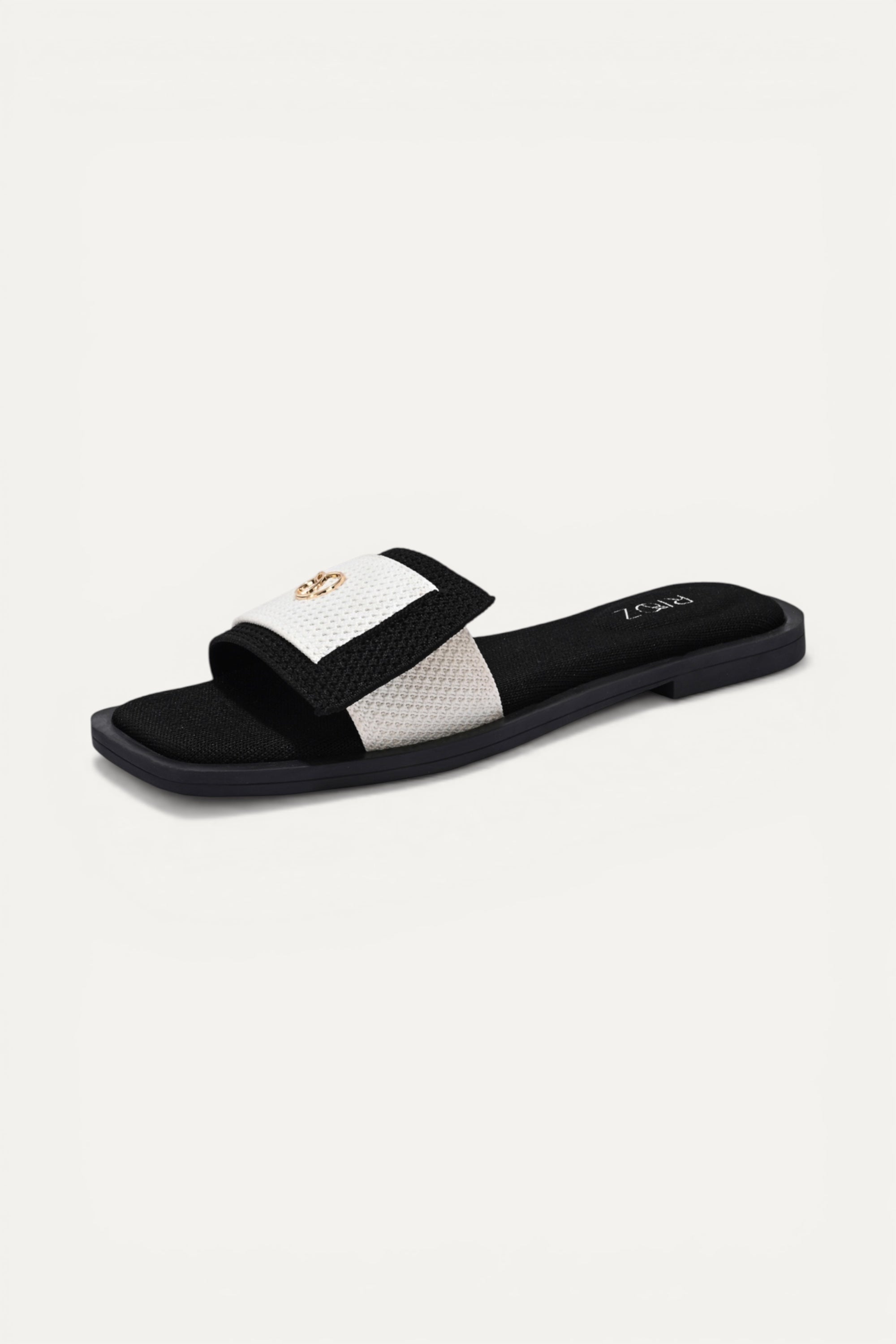 Rioz black and white knit origami slides with gold emblem detail and square toe. Sustainable, 3D-knit, machine washable.