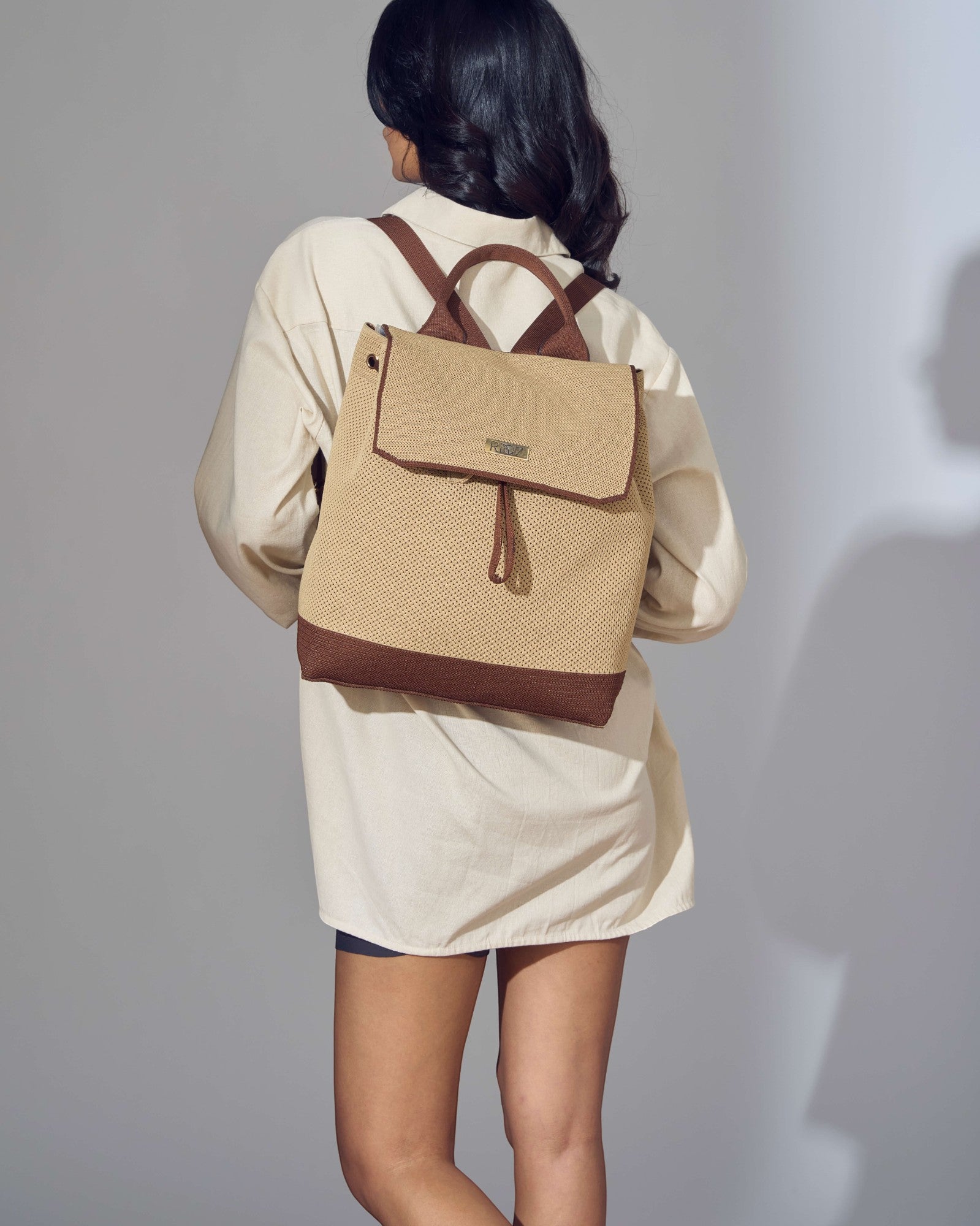 Model wearing eco-friendly Rioz backpack – lightweight, machine-washable and spacious, made from recycled PET bottles.