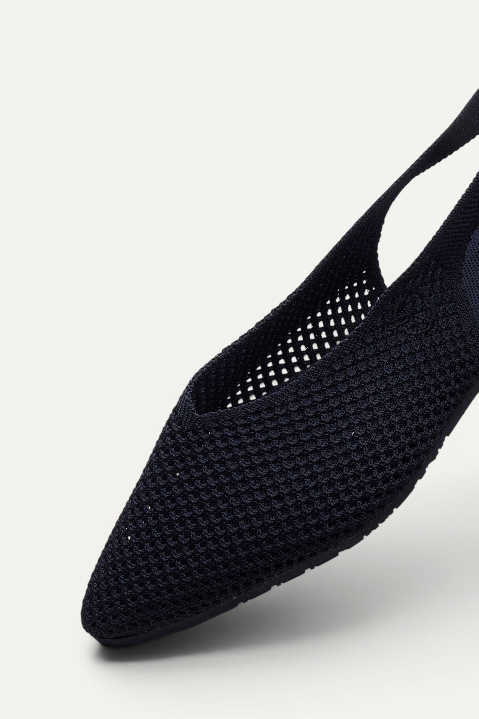 Side view of Rioz Black Airknit Slingbacks, sleek pointed-toe knit flats with open-mesh upper.