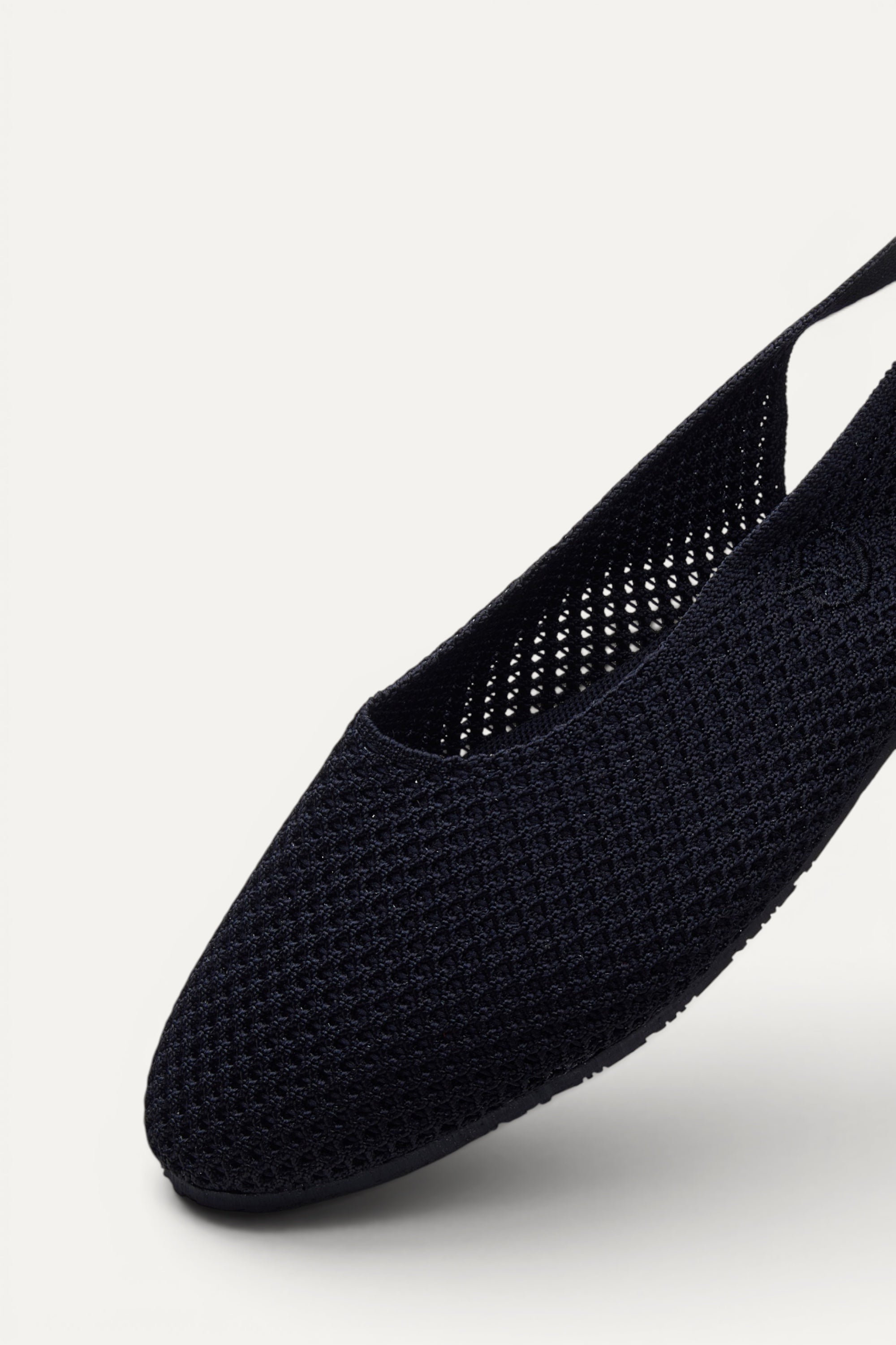 Side view of Rioz Black Airknit Slingbacks, breathable open-mesh almond-toe knit flats for women.