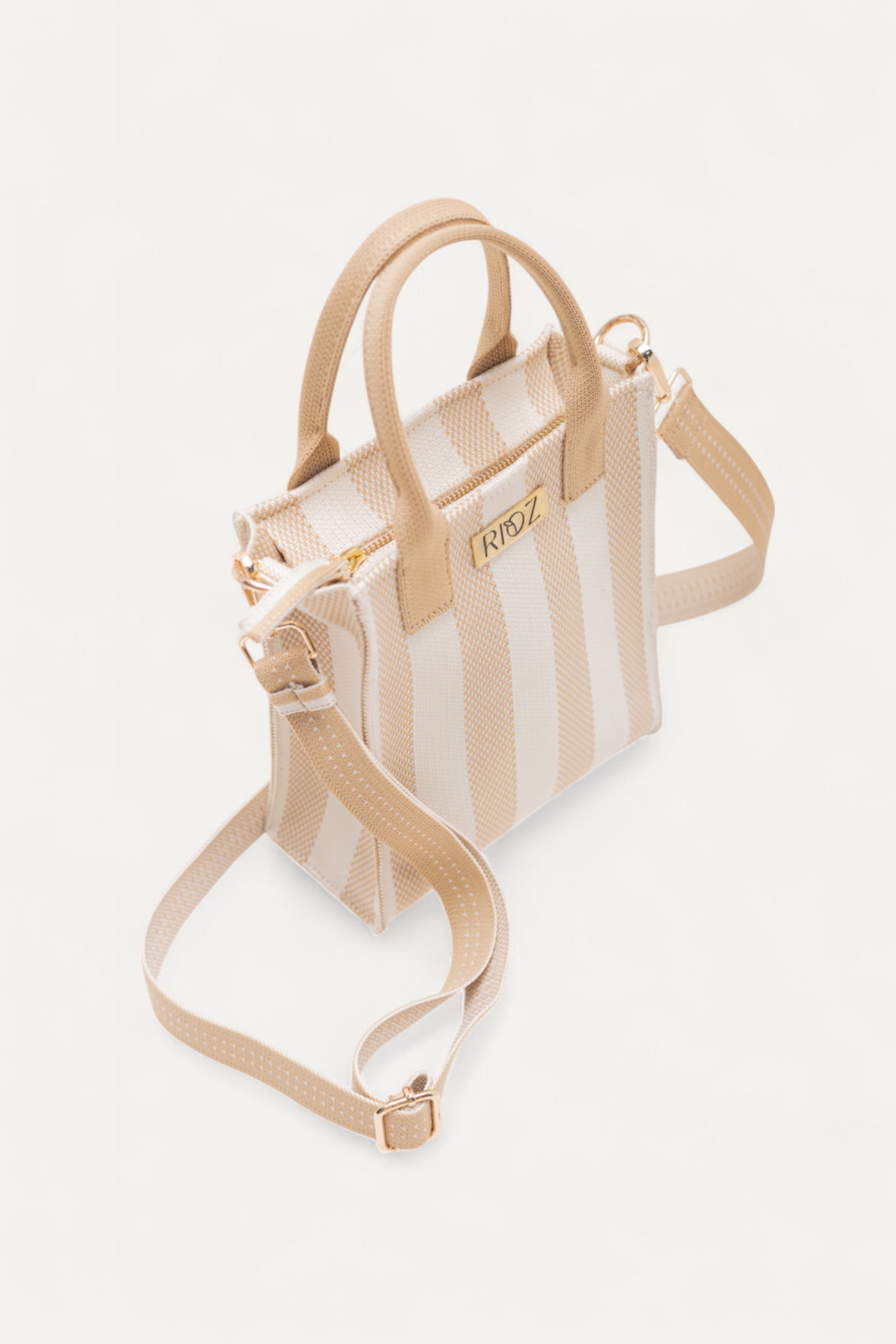 Angled top view of Midday Mini tote bag in ivory and wheat stripes by Rioz, showcasing its compact interior and adjustable strap; eco-friendly and lightweight.