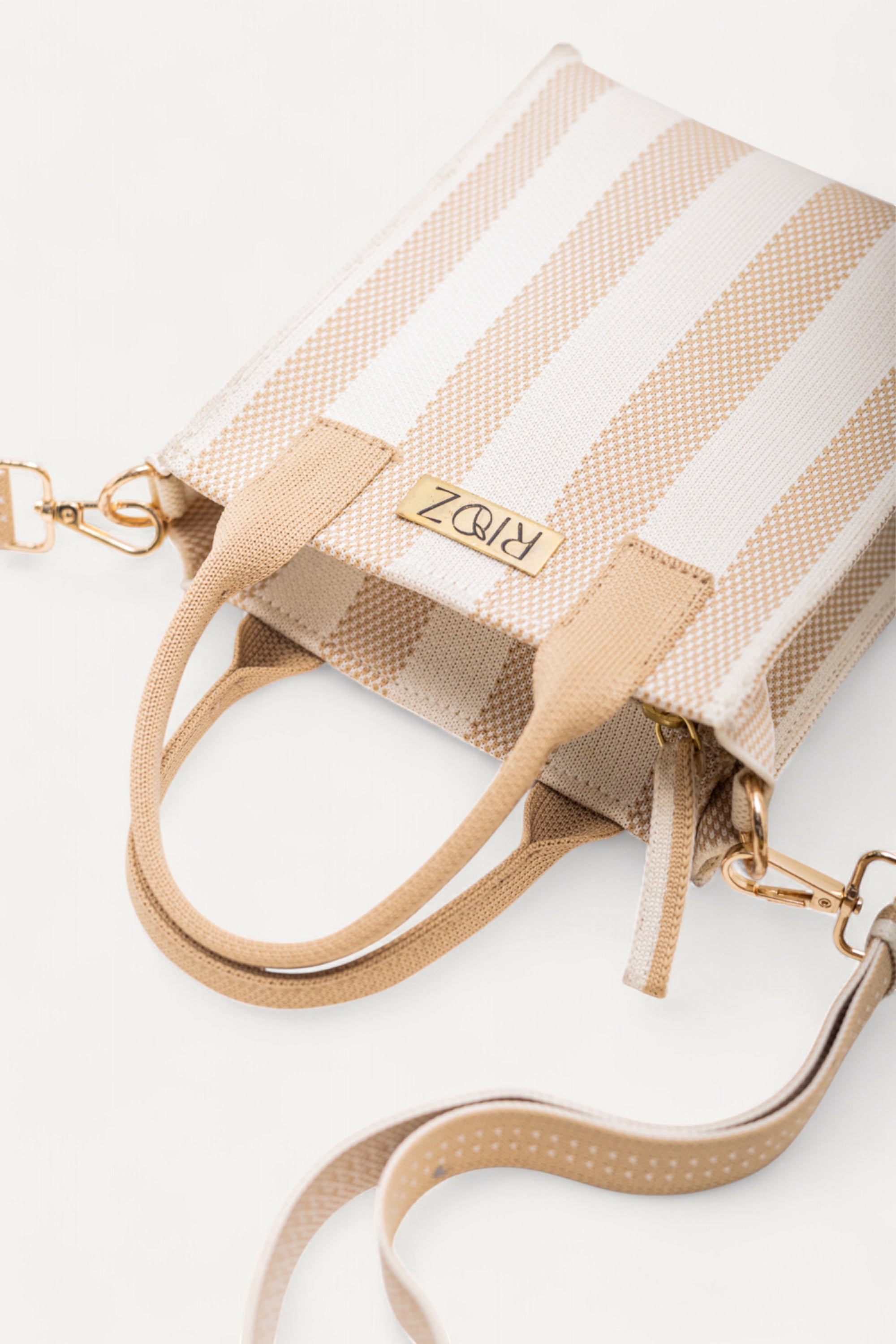 Detailed close-up of Midday Mini tote bag by Rioz showing the ivory and wheat striped fabric, handles and clasp attachments; eco-friendly and lightweight design.