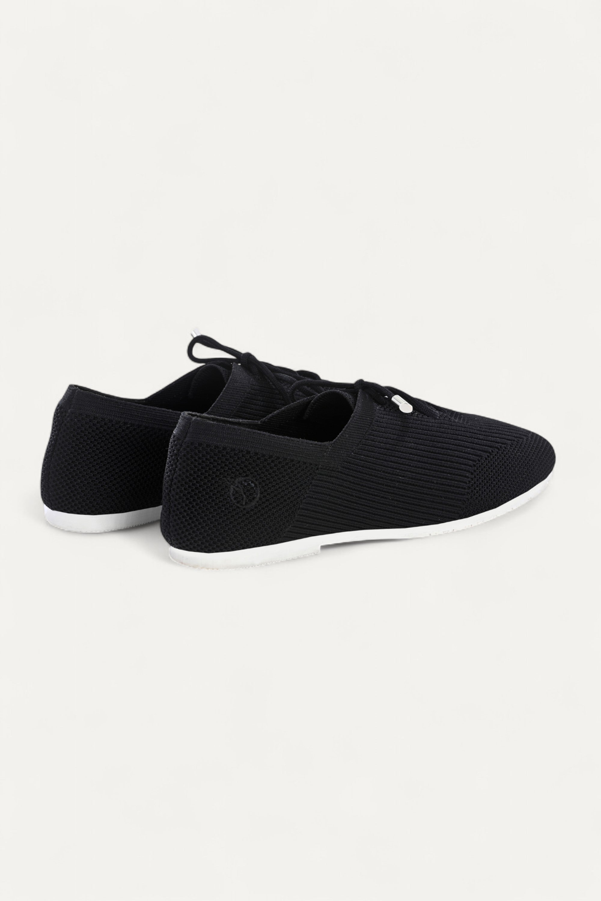 Rioz black knitted lace-up shoes with breathable mesh design, lightweight casual sneakers for women with flexible sole, angled view on neutral background.
