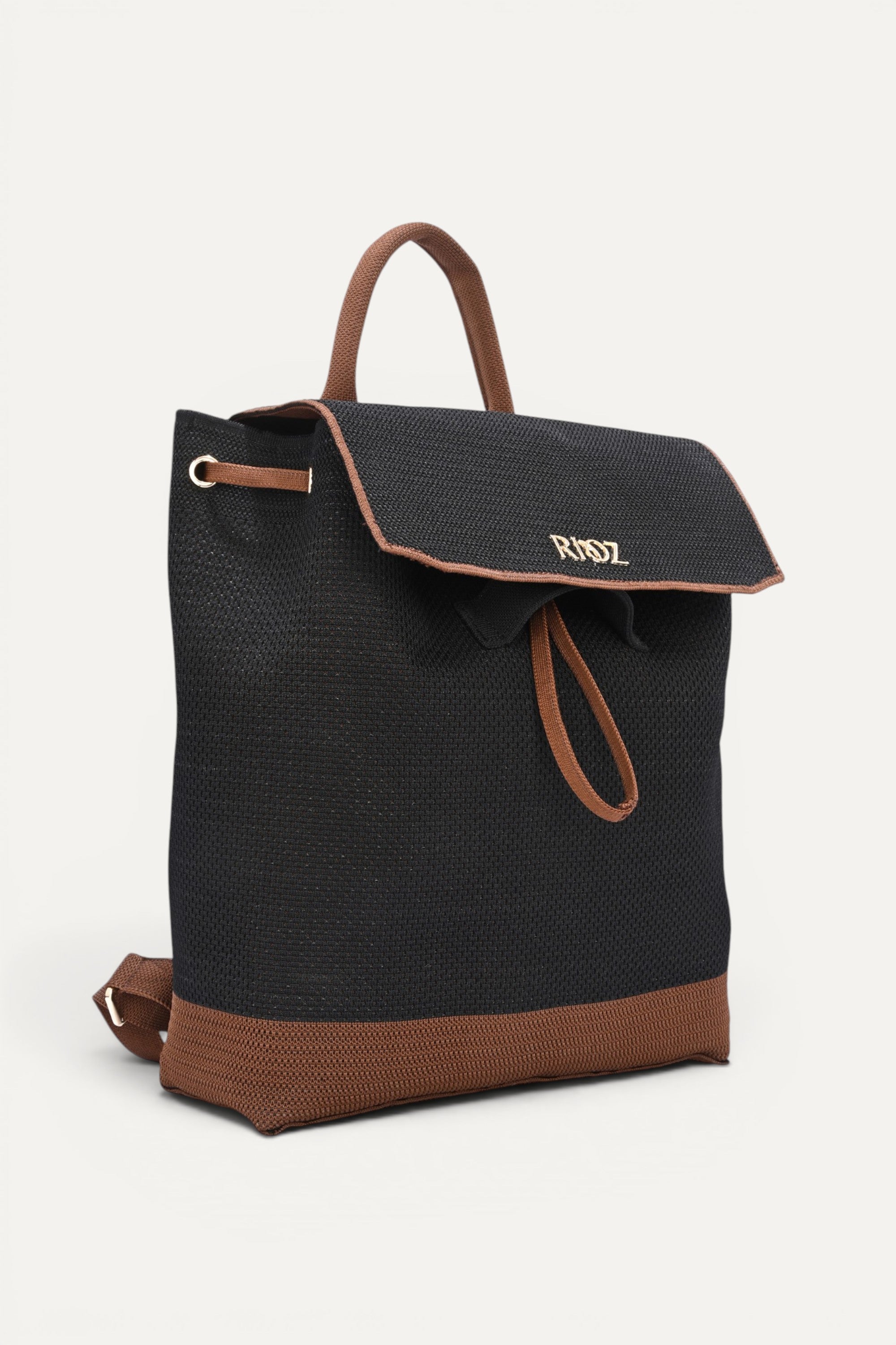Eco-friendly black woven backpack with brown trim, flap closure and drawstring detail, top handle and shoulder straps, minimalist sustainable design and made from recycled PET bottles for  for everyday use.