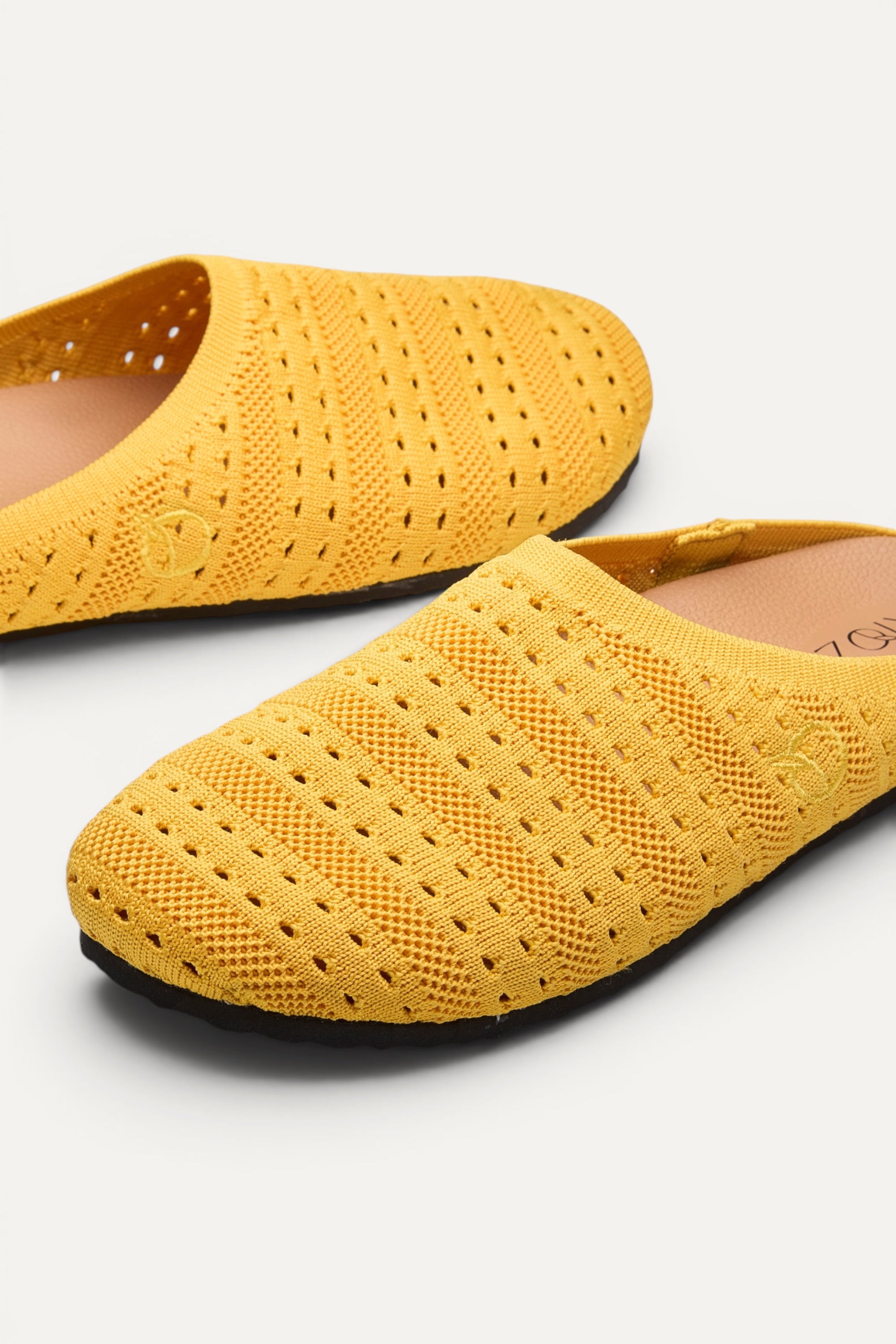 Side view of Rioz Yellow Lumi Mules, breathable pointelle knit closed-toe slip-on clogs.
